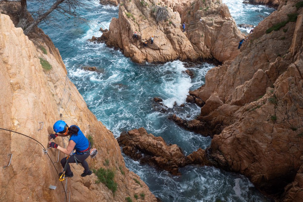 muž na feratě lezoucí po skalách